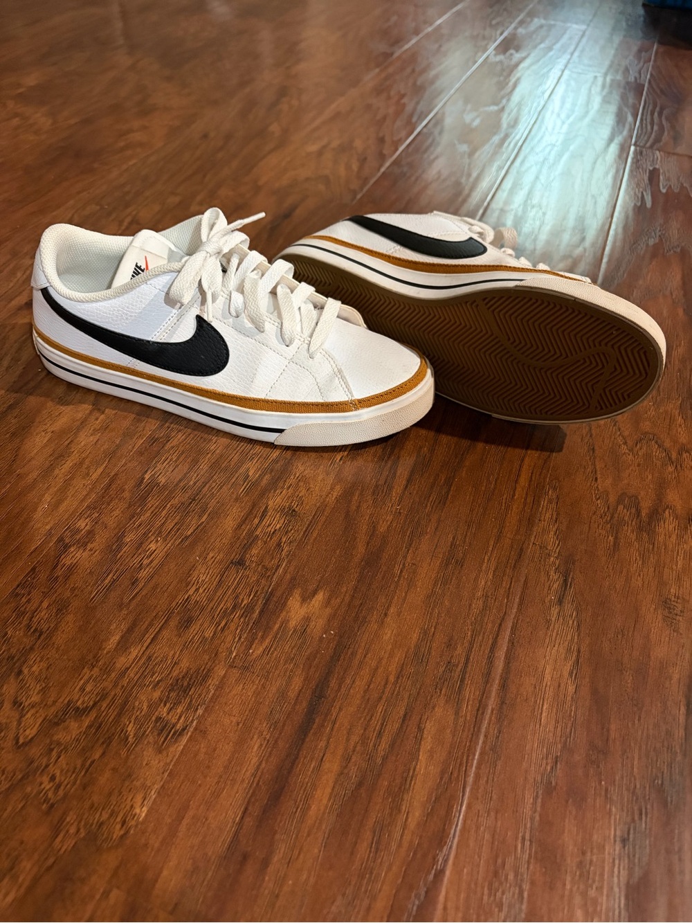 Nike White Low-Top Sneakers with Black Swoosh and Gold Trim